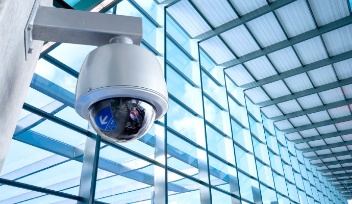 Commercial security camera mounted on a modern glass building structure