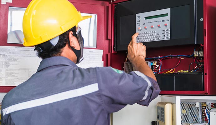 professional inspecting fire alarm