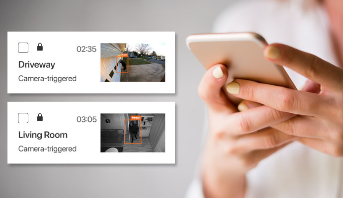 Person viewing camera-triggered security alerts and notifications on a smartphone