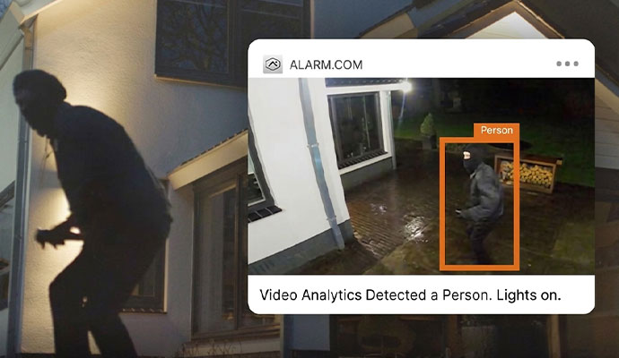 Home security system alert showing a burglar detected outside a house at night