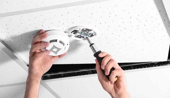 Person installing a smoke detector